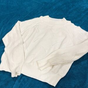 White pearl detailed mock neck sweater with cold shoulder detail.